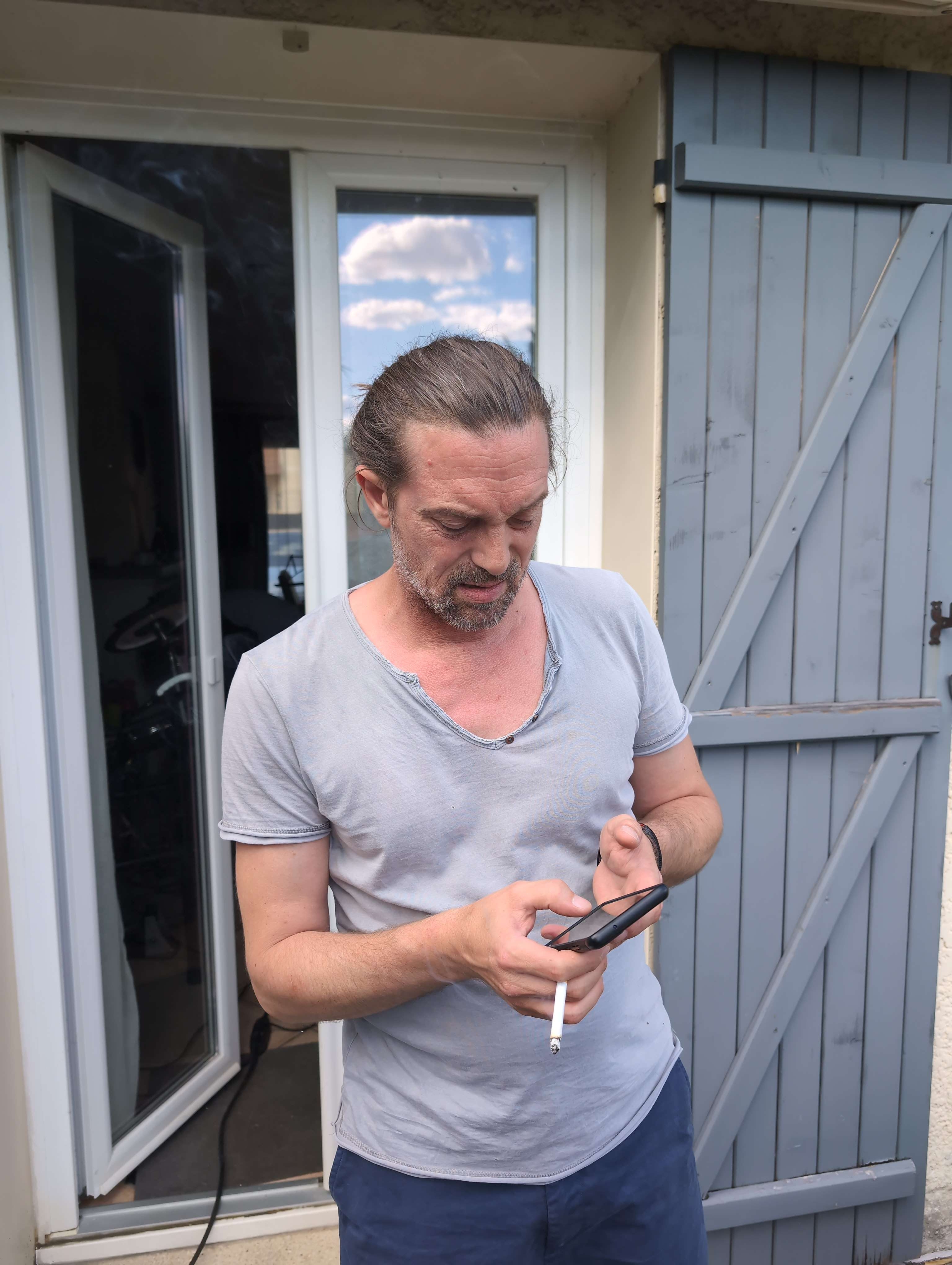 Portrait de membre du groupe NFNR fumant devant la maison